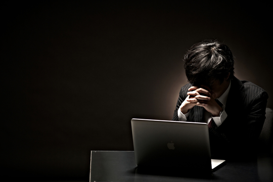 パソコンを前に悩む男性